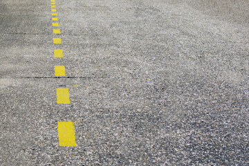 Yellow markings drawn on an asphalt road.