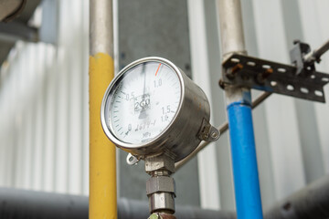Industrial pressure gauge on the background of a chemical plant. Pressure gauge readings.