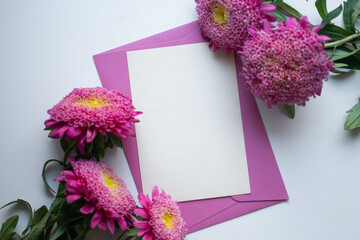 invitation card mockup with autumn flowers. asters on a white table