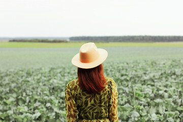 a woman in a field with cabbage. autumn harvest season