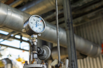 Industrial pressure gauge on the background of a chemical plant. Pressure gauge readings.