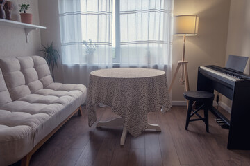 Room interior with table, sofa and electric piano. Window with a floor lamp in a living room with a musical instrument