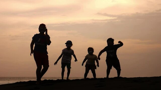 The joy of children dancing on the beach at sunset in the afternoon