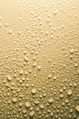 Water drops on smooth surface, yellow background