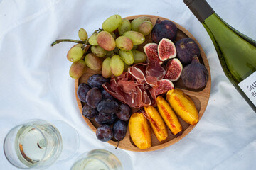picnic by the sea. wine in glasses. figs, jamon, peach and other snacks.
pleasant evening picnic. healthy food