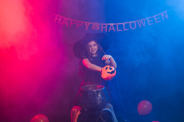 Little witch child cooking potion in the cauldron on Halloween.
