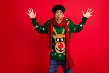 Portrait of attractive cheerful amazed guy wearing casual festal jumper having fun time isolated over bright red color background
