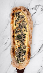 Top view of a pizza with mozzarella cheese, green onions and mushrooms. 