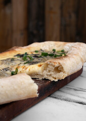 Sliced pizza with mozzarella cheese, green onions and mushrooms.