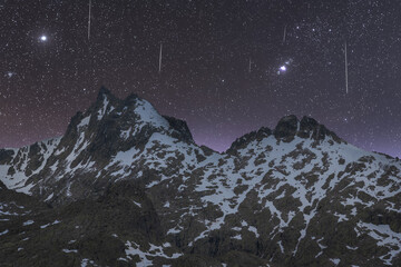 Snowy mountains under starry sky at night