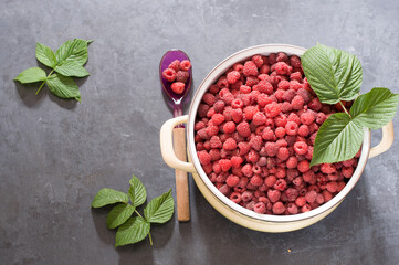 a full pan of ripe raspberries and a spoon for jam, a large harvest of healthy berries, a healthy diet. Favorite delicacy, preservation of Natural vitamins for the winter