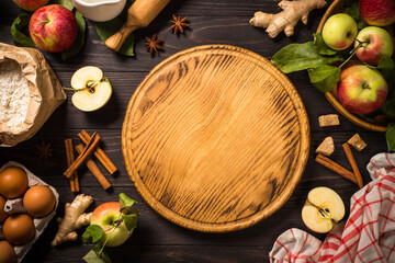 Autumn baking background. Food frame. Ingredients for cooking apple pie at dark wooden table. Top view with copy space.