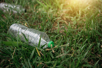 plastic bottle on green grass. Ecology problem. Environmental pollution.