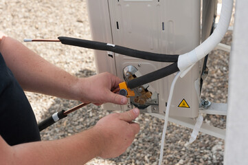 the worker installing and connecting a new air conditioner unit