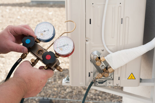 the worker installing and connecting a new air conditioner unit