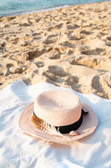 Fototapeta na wymiar Summer set with a hat and sunglasses on the beach by the sea at a sunrise. Ready to summer.