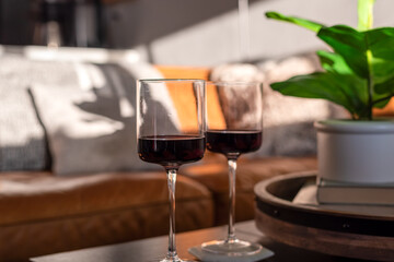 Two wine glasses on a coffee table in natural light