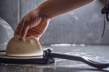 Preparing Dough for Mexican corn tortillas for tacos with tortilla press on grey table top. 