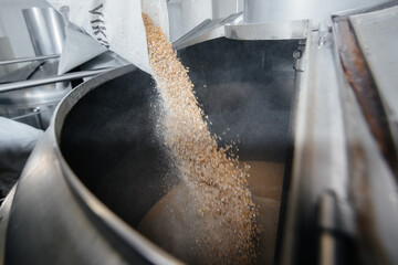 The process of filling malt in a container for making beer. Traditional brewing.
