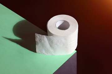Roll of toilet paper on edge, concept for sale and necessity, on dark background with copy space