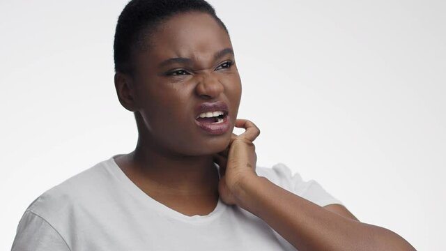 Young unhappy african american woman suffering from tonsils inflammation, touching her painful neck