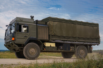 Obraz premium British army MAN SV 4x4 army lorry logistics vehicle truck driving along a dirt track in action on a military exercise, Salisbury Plain UK