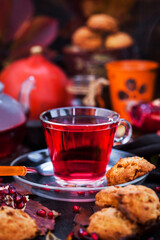 Glass cup of hot red tea and fresh homemade delicious apple cookies on rustic autumn background