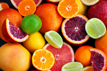 Close up of fresh juicy citrus fruits - oranges, mandarins, lemons and limes, top view