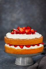 Victoria`s sponge cake, delicious homemade vanilla cake decorated with whipped cream and fresh strawberries
