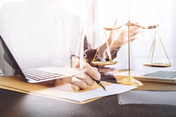 Justice and law concept.Male judge in a courtroom with the gavel, working with, computer and docking keyboard, eyeglasses, on table in morning light