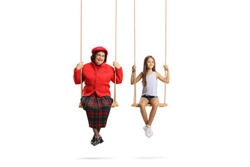 A grandmother with her granddaughter sitting on swings