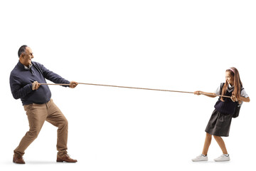 Full length profile shot of a schoolgirl pulling a rope from one side and mature man on the other...