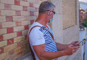 Hombre de mediana edad con mascarilla sanitaria de vacaciones en Altea con Tablet en video...