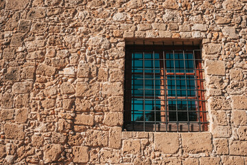 Fototapeta na wymiar Old brick wall and window. Grate on the window