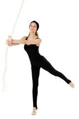 Attractive sports teen girl swinging on rope swing