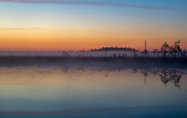 Fototapeta na wymiar Fog over the lake. Fog over the forest. Fog over the swamp. Sunset. Dawn. Northern nature. Summer and autumn nature. Beautiful landscape.