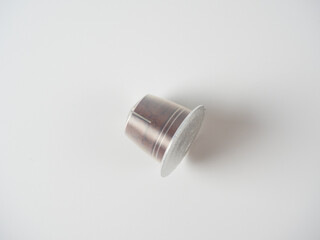 a plastic capsule with ground coffee on a white background. Non eco friendly packaging that cannot be reused