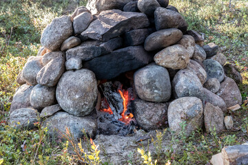 Hiking bath. Sauna in the forest. Stove made of stones. Fireplace in the woods.