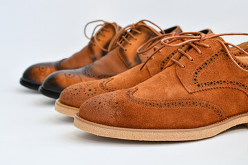 Clasic brown suede and leather derby shoes isolated on white background. Selective focus.