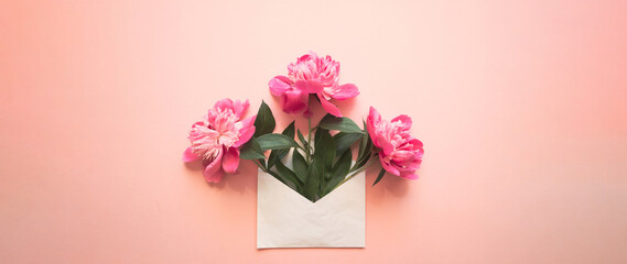 White envelope with pink peonies inside on a pink background. Template for newsletters and other mail designs