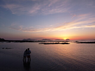Fototapeta premium a lovely couple in the beach with the sunset in the background 
