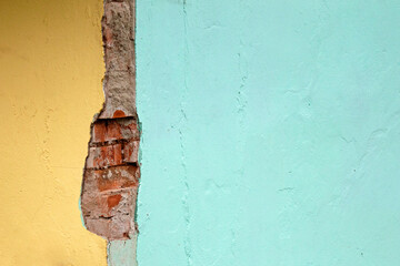 backdrop of an old and deteriorated house wall in yellow and blue colors.