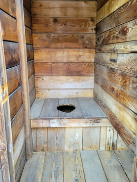 A rustic, historic wooden toilet in an outhouse in the American west.