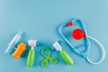 A set for children to play doctor, a game set, a toy stethoscope, a syringe, a hammer, spikes, pills, on a blue background