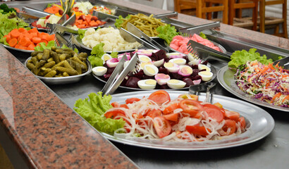 An all-you-can-eat restaurant buffet composed by regular salads like pickles, beets, carrots and more.