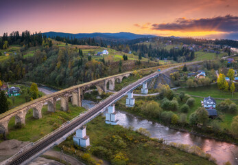 Beautiful old viaduct at sunset in carpathian mountains in autumn in Ukraine. Aerial view of...