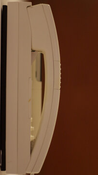 Telefone Branco de perfil, em fundo castanho