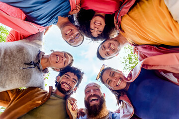 directly below portrait of multiethnic group of friends posing in the street outdoors laughing and...
