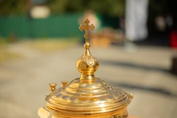 Fototapeta na wymiar Orthodox cross on a gold object. Goldware for religious rites.