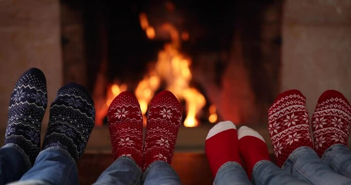 Family in Christmas socks near fireplace